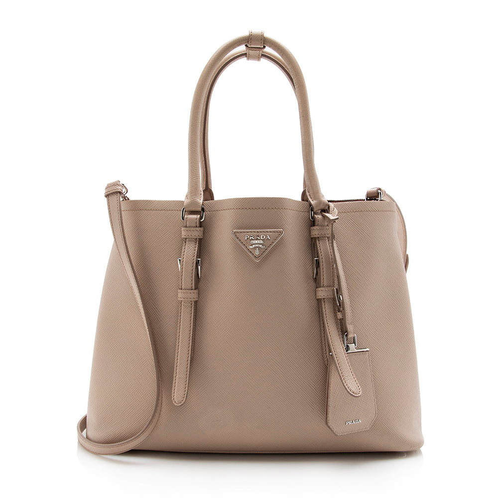 The Prada Double bag in Saffiano Cuir leather comes with a double handle  and detachable shoulder strap. A flap pocket …